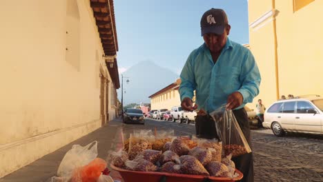 Ein-Guatemaltekischer-Mann,-Der-Auf-Der-Straße-Bohnen-Verkauft,-Füllt-Und-Wiegt-Die-Tüte-Und-Reicht-Sie-Dann-Dem-Kunden