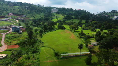 Aerial-view-over-a-golf-course,-toward-the-Hôtel-Mont-Fébé-in-Yaounde,-Cameroon
