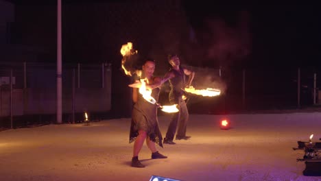 Fiery-Duo:-Man-and-Woman-Fire-Breathers-Spin-Flaming-Baton-in-Mesmerizing-Display