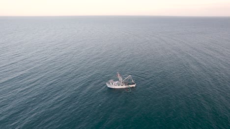 Aerial-shot-drone-shot-lowering-to-shrimp-boat-while-fishing-in-Baja,-Mexico