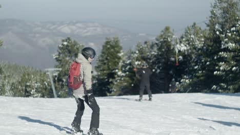 Skifahrer-Und-Snowboarder-Rutschen-In-Zeitlupe-Die-Hänge-Hinunter,-Winter-Sonnig