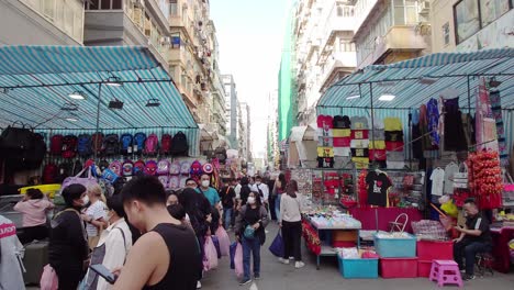 Shot-of-crowded-MongKok-Ladies'-Market-with-stalls-and-shops-on-either-side-of-the-lane-and-during-daytime-in-Hong-Kong,-China
