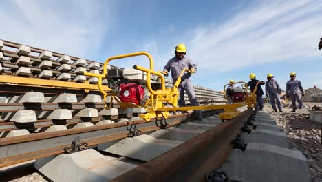 Construction-workers-in-safety-gear-operate-machinery-on-railway-tracks-in-the-province-of-Salta