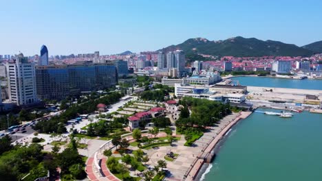 Luftbild-Rechts,-360-Grad-Panoramablick-Auf-Die-Wunderschöne-Stadtlandschaft-Von-Weihai-Im-Xingfu-Park-Direkt-Am-Meer-Mit-Der-Insel-Im-Hintergrund