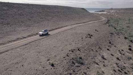 Aereal-drone-shot-of-a-truck-driving-away-from-the-beach-in-Baja-California,-Mexico