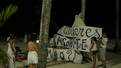Heiratsantrag-Eines-Jungen-Paares-Am-Nächtlichen-Strand-Mit-Freunden,-San-Andres,-Kolumbien