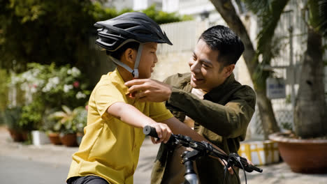 Father-putting-a-helmet-on-his-son