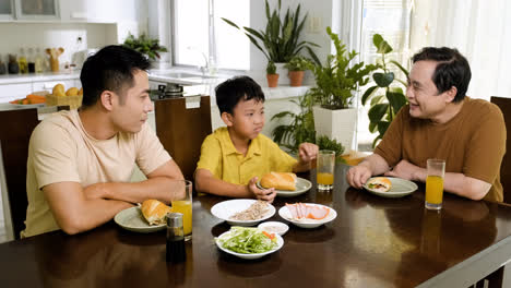 Asiatische-Männer-Und-Jungen-Sitzen-Am-Tisch