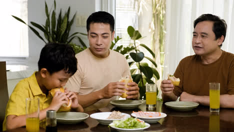 Asiatische-Männer-Und-Jungen-Sitzen-Am-Tisch
