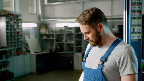 Man-in-blue-overalls-with-arms-crossed