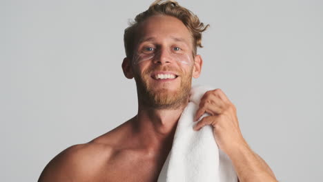 Man-with-eye-patches-holding-towel-on-his-shoulder