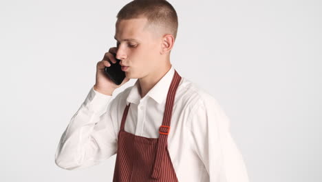 Young-waiter-talking-on-the-phone