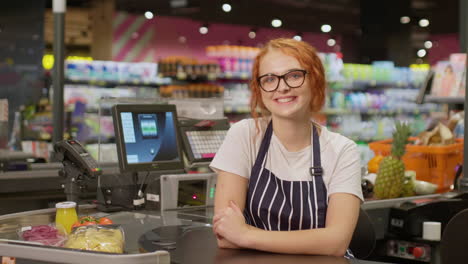 Junge-Verkäuferin-Lächelt-Und-Blickt-In-Die-Kamera-In-Einem-Supermarkt