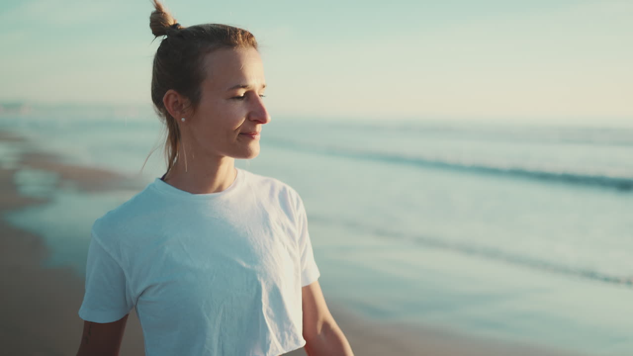 Free stock video - Sporty girl walking and enjoying morning on the beach.