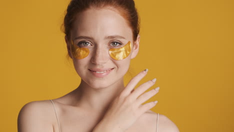 Redheaded-girl-in-front-of-camera-on-yellow-background.