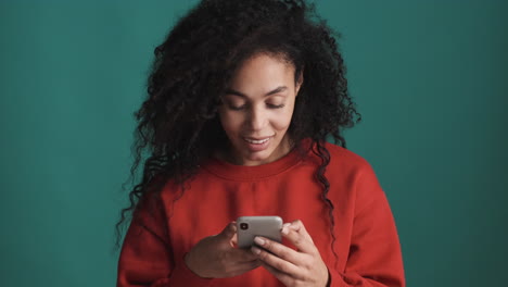 Afroamerikanische-Frau-Mit-Smartphone-Auf-Blauem-Hintergrund.