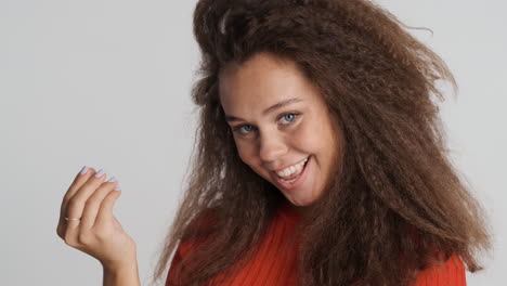 Caucasian-curly-haired-woman-showing-money-gesture.