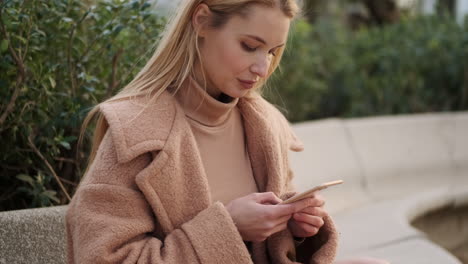 Young-woman-using-phone-outdoors.