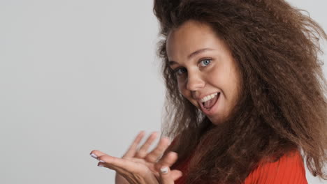 Caucasian-curly-haired-woman-showing-money-gesture.