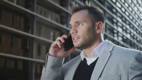 Businessman-talking-on-mobile-phone-at-street