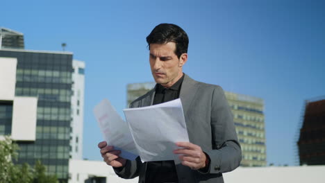 Businessman-working-with-papers-on-street