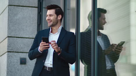 Young-businessman-using-smartphone-outside