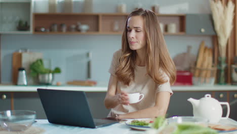 Woman-working-on-laptop-at-kitchen