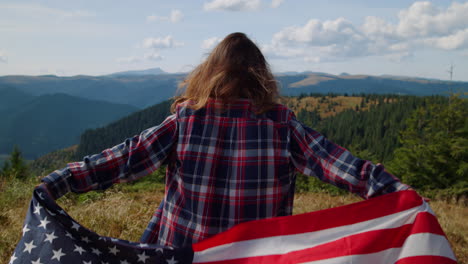 Woman-hiking-in-mountains-with-american-flag