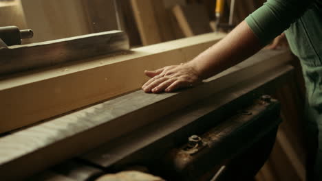 Man-preparing-wooden-plank-for-product-indoors