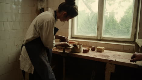 Beautiful-woman-sculpting-clay-pot-in-pottery