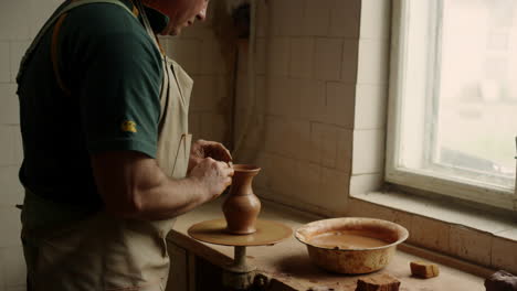 Ceramist-making-clay-product-in-pottery-wheel