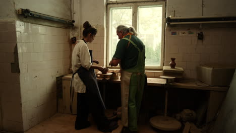 Young-woman-making-clay-pot-in-pottery-studio