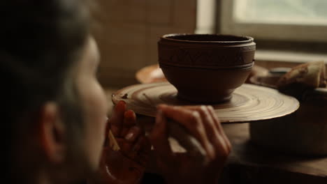 Focused-woman-using-tools-in-pottery