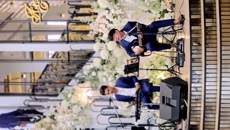A-drummer-and-a-guitarist-are-playing-their-musical-instruments-and-singing-songs-for-a-wedding-event-in-Bangkok,-Thailand