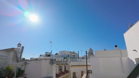 A-rooftop-view-under-a-bright-sun-showcases-the-white-washed-buildings-typical-of-Andalusian-architecture