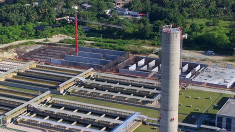 Aerial-view-of-treatment-plant-with-crane-and-tower-at-sunny-day,-Dominican-Republic---panorama-view