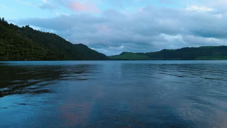 Gelassenheit-Bei-Sonnenuntergang:-Lila-Wolken-Tanzen-In-Diesem-Faszinierenden-Stockvideo-Anmutig-über-Einem-Ruhigen-See