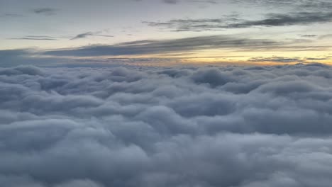 Clouds-scene-at-dawn-flying-over-a-sea-of-clouds,-as-seen-by-the-pilots-in-a-real-flight-at-10000m-high