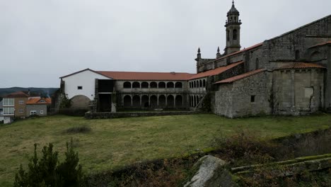 Pan-across-Santa-Maria-de-Xunqueira-monastery-rear-courtyard-and-stone-buildings
