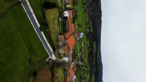 Rear-pullback-aerial-from-Santa-Maria-de-Xunqueira-monastery-on-cloudy-day