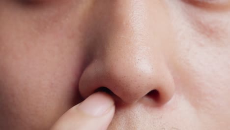 Close-up-of-a-young-man-picking-nose-with-finger