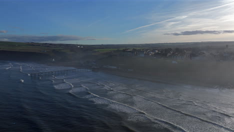 Wide-Angle-Aerial-Drone-Shot-of-Saltburn-by-the-Sea-and-Pier-at-High-Tide