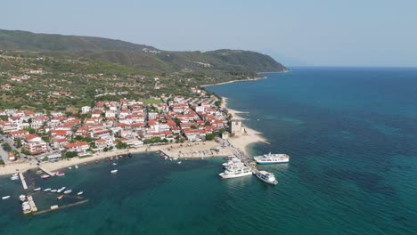 Ferry-Boats-at-Port-in-Ouranoupoli,-Athos,-Halkidiki,-Greece---Aerial-4k-Circling