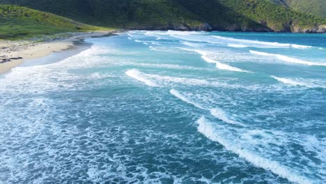 Stunning-flight-over-waves-of-Caribbean-beach-in-majestic-Tayrona-National-Park,-Colombia