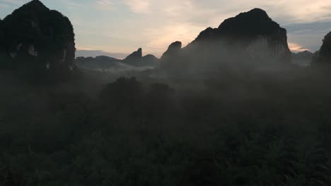 Misty-Morning-Limestone-Cliffs-Rock-Formations-in-Krabi-Thailand,-Flying-through-Mist-Aerial-Drone-Establisher