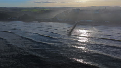 High-Establishing-Drone-Shot-of-Saltburn-by-the-Sea-and-Pier-at-High-Tide