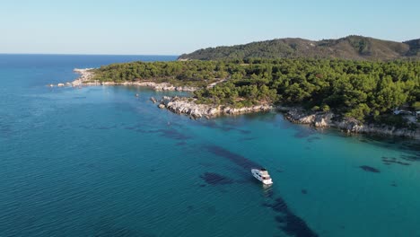 Boat-anchored-along-Halkidiki-Coast-in-Sithonia,-Greece---Aerial-4k-Circling