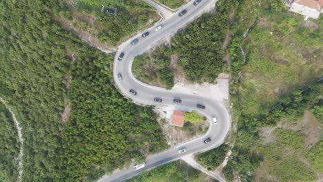 Ascenso-Aéreo-Sobre-Una-Carretera-Serpenteante-De-Montaña-Albanesa-Con-Tráfico-Intensivo