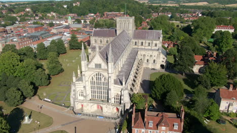 Lowering-drone-shot-of-Winchester-Cathedral-filmed-in-Summer-in-Hampshire,-UK
