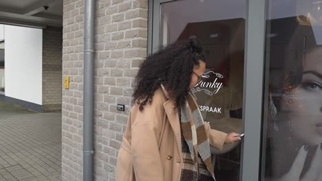 Curly-woman-walking-inside-beauty-salon-for-pedicures-and-nails